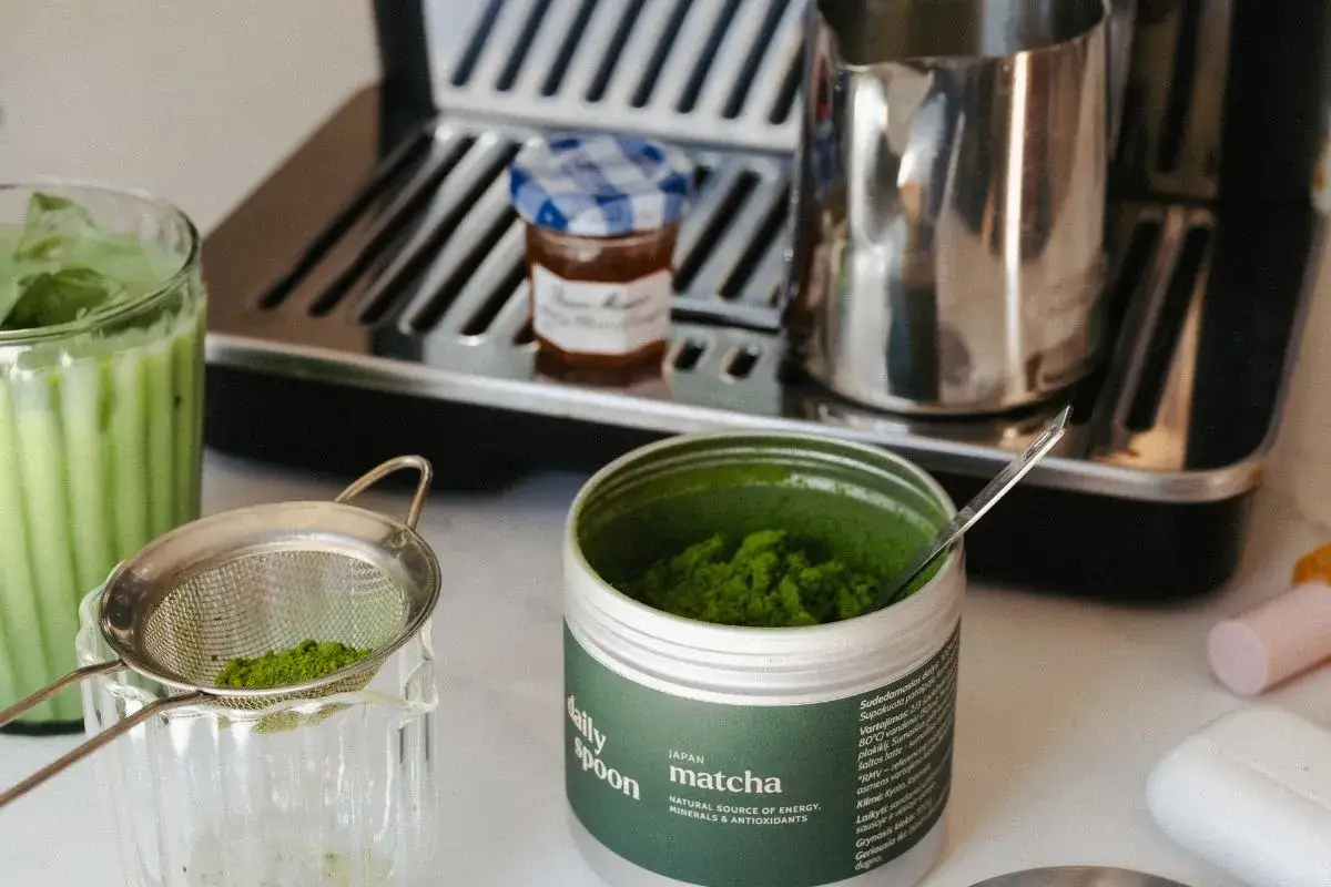 Zielony proszek matcha w puszce, gotowy do przygotowania orzeźwiającego napoju. Co to matcha? To japońska herbata, źródło energii i antyoksydantów.